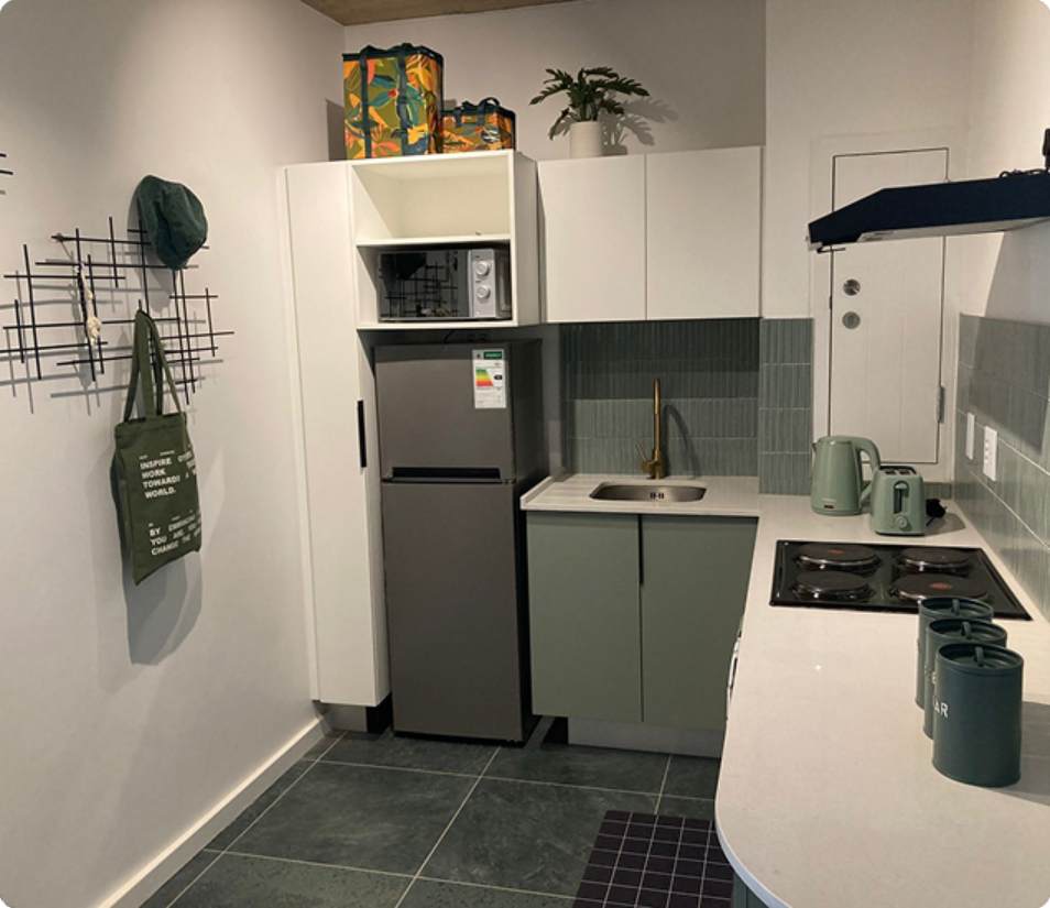 Main Road Standard Bachelor kitchenette, green cabinetry and appliances.