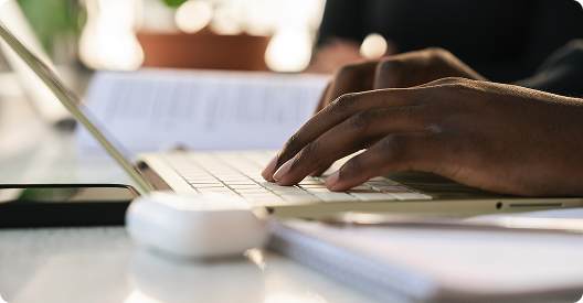 Hands typing on a laptop while studying